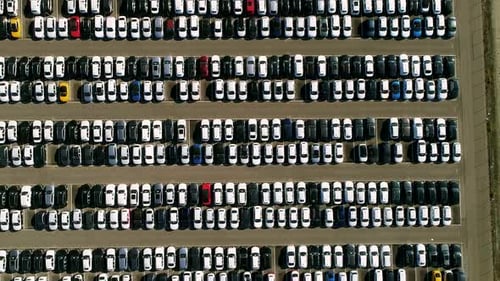 Aerial footage of finished cars ready to be shipped on huge distribution center