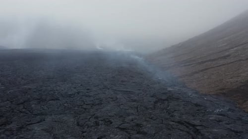Dramatic cloudy weather over dark basalt lava field in Iceland, aerial