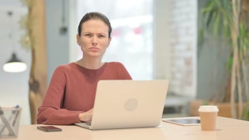 Woman at Laptop Frowning in an Office