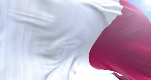 Waving Flag with Red and White Stripes Against Blue Sky