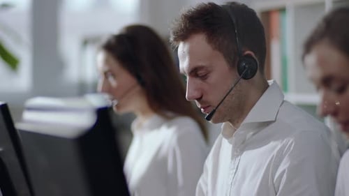Seitenansicht der arbeitenden Bediener Selektiver Fokus auf positive, gutaussehende kaukasische männliche Kundenservices