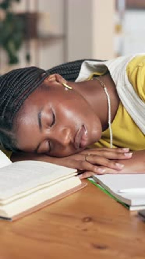 Woman Sleeping on Book at Table Indoors
