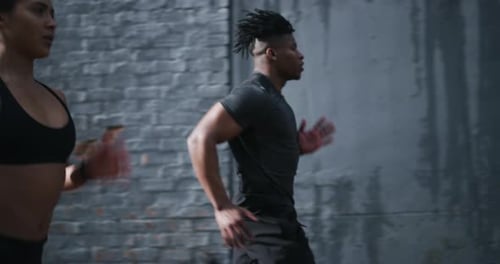 Man and Woman Jogging Down a City Street