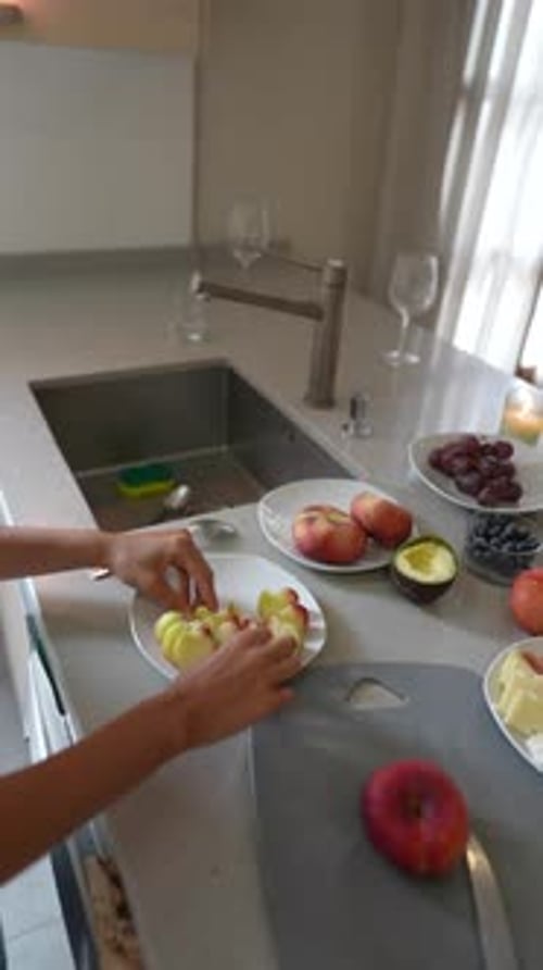 Person Cuts Apple in Bright Modern Kitchen