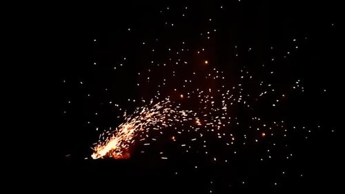 Super slow motion of Fire flames flying all over the place while using the wind blower to prepare th