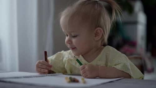 Adorable Toddler Drawing with Colored Pencils at Table