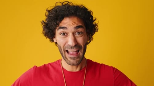 Close up, wonder man put his hands on head looking at camera isolated on yellow background