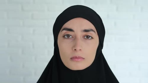 Woman in Black Head Covering Stares Forward