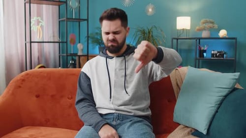 Upset Caucasian Man Showing Thumbs Down Dislike Bad Work Disapproval Dissatisfied Feedback at Home