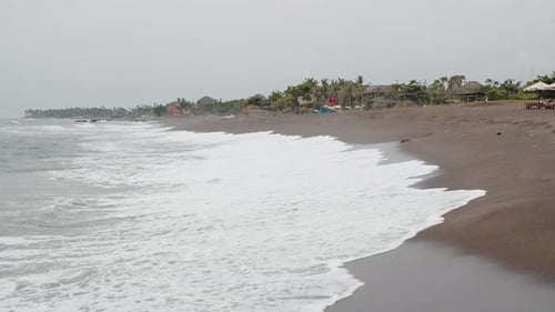 Black Beach with Volcanic Sand and Waves the Ocean Lapping the Shoreline