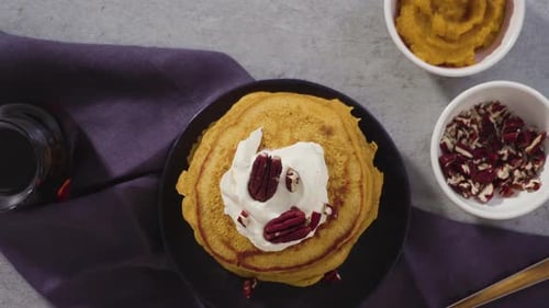 Pumpkin Pancakes Topped with Whipped Cream and Pecans