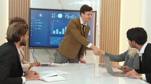 Smiling Business Team Meeting Shaking Hands in Modern Office
