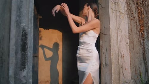Elegant Woman Dances With Her Shadow in Doorway