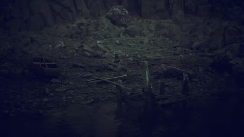 Dark Abandoned Shoreline with Wooden Pier and Boat