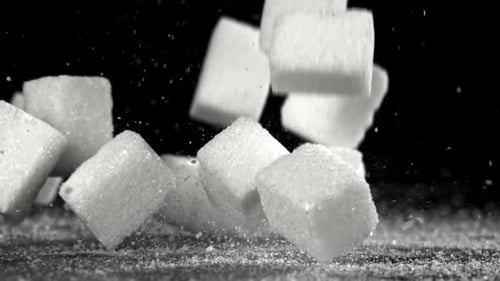 Zuckerwürfel fallen auf den Tisch, gefilmt mit einer Hochgeschwindigkeitskamera mit 1000 Bildern pro Sekunde