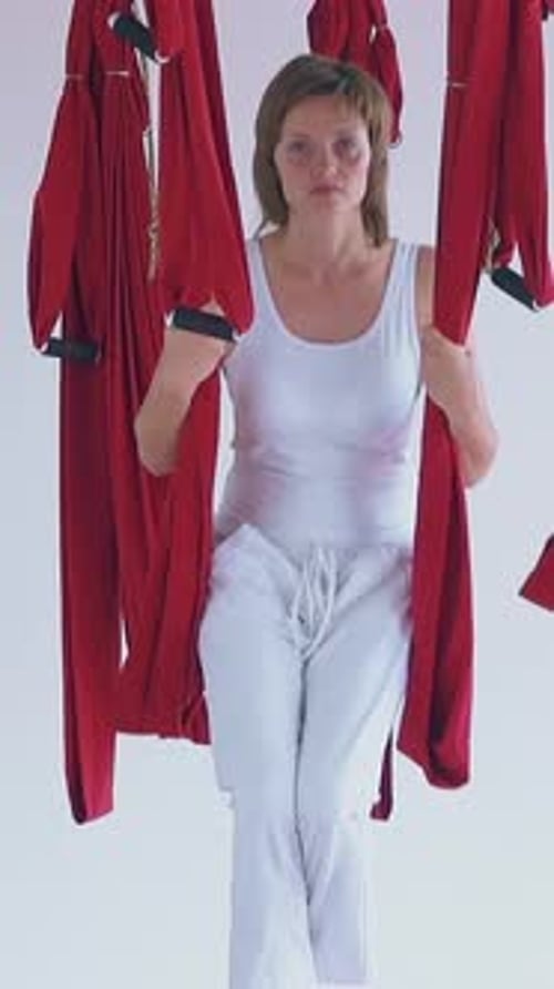 Woman in aerial yoga hammock performing fitness exercises