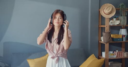 Young Woman Dancing at Home with Headphones