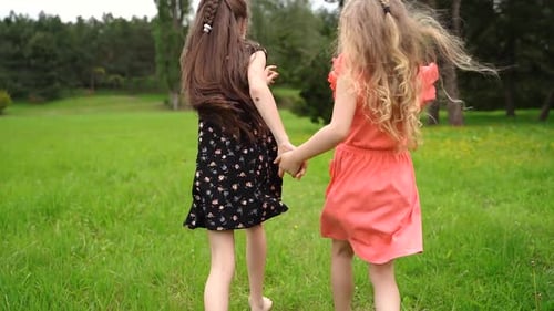 Sisters Hold Hands And Run In Slow Motion Through Beautiful Meadow