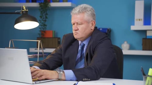 Frustrated Businessman Working on Laptop in Office