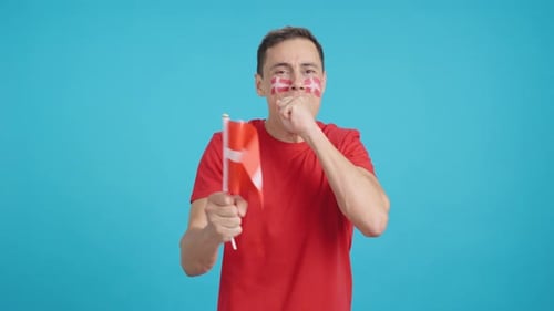 Man Cheering for Denmark During a Match That is Lost