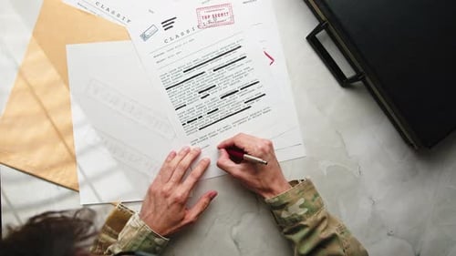 Person Signing Classified Documents with Top Secret Stamp