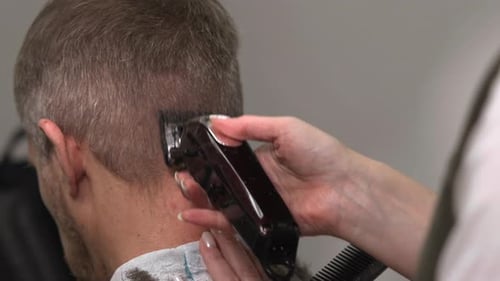 Friseur formt Hals- und Seitenpartien präzise Nahaufnahme von professionellem Haarschnitt, schonend Media