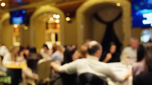 A Beautifully Blurred Ambiance Capturing the Lively Scene of a Restaurant with Diners Engaged in