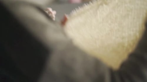 Woman Knitting a Cream Colored Wool Blanket Indoors