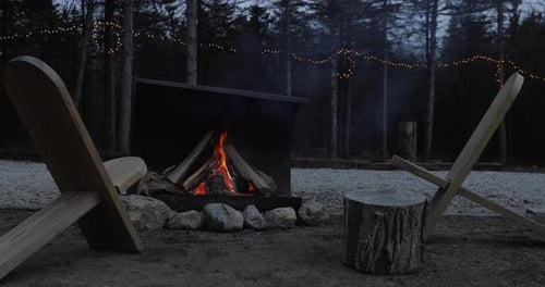 4K CAMPFIRE AT DUSK. A cozy campfire in the fall season. Crackling fire in the woods.