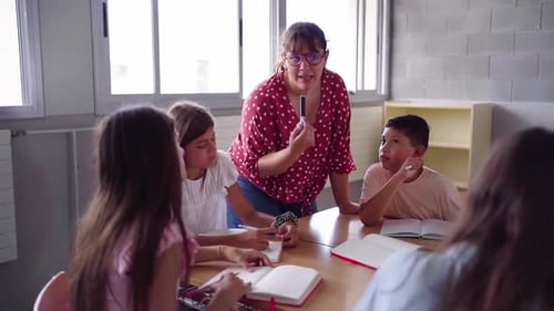 Elementary School Teacher Explaining Lesson to Students in Classroom
