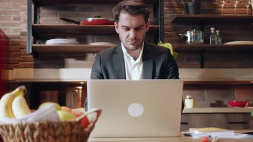 A Young Professional is Working Remotely From a Cozy and Inviting Kitchen Environment