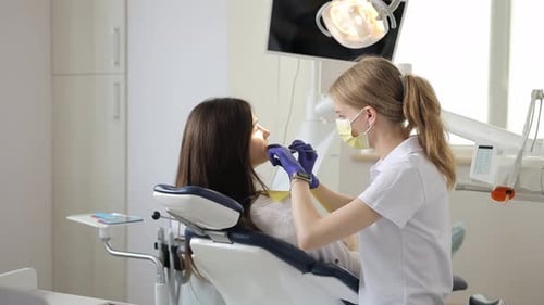 A Female Dentist Examines a Patient's Teeth During an Appointment at a Dental Clinic