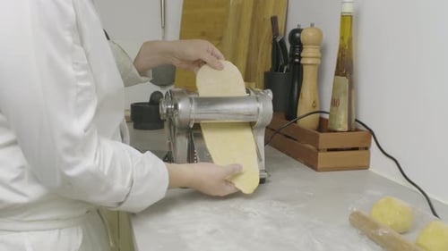 Passing pasta dough through cooking press machine. Closeup