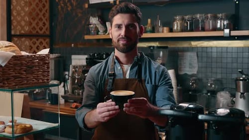 Smiling Barista Holding Coffee in Coffee Shop