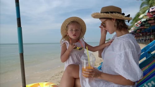 Madre e hija relajándose en la playa