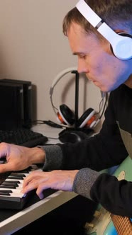 Young Adult Playing Keyboard at Desk Indoors