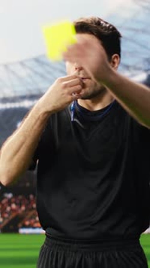 Vertikales Video Fußballschiedsrichter in Schwarz, der einem protestierenden Spieler auf dem Spielfeld die gelbe Karte zeigt