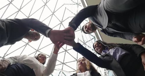 Team Puts Hands Together in Corporate Office