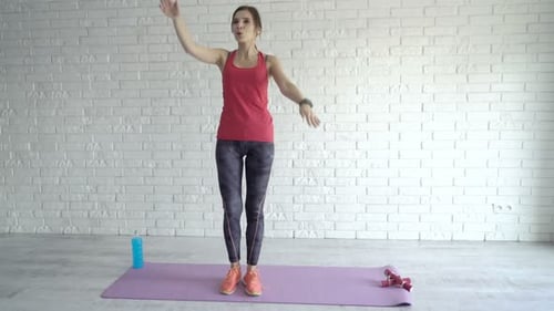 Young Woman Exercising at Home on Yoga Mat