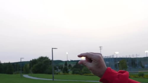Adult Man's Hand Trying to Pinch the Setting Sun