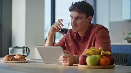 Adult Man Using Tablet at Breakfast Table