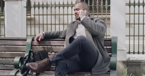 Trendy, stylish businessman on a phone call checking time, schedule or making business appointment