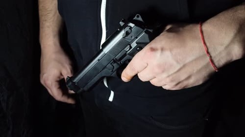 Hand Pulling Gun From Hoodie Pocket Close Up
