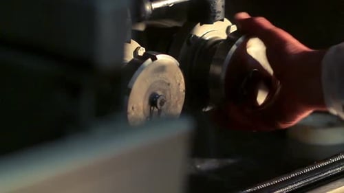 Hand opens metal valves on a manufacturing machine