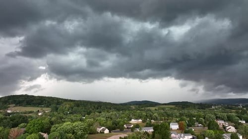 An aerial view of a large rainstorm moving over the countryside.