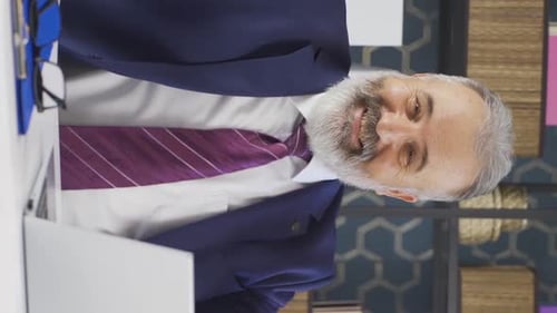Enthusiastic Businessman Talking at His Desk, Vertical Video
