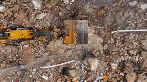 Excavator arm demolishing an old building, Aerial view