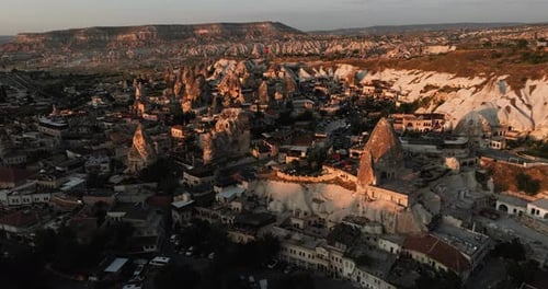 Colorful balloons soar above Cappadocia’s rocky terrain during early morning blue hour, a magical mo