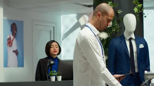 Retail Assistant Examines Apparel on Racks in a Trendy Boutique