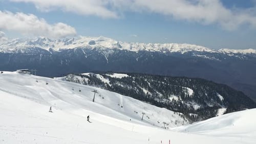 Station de ski avec pistes et téléphériques au milieu des montagnes ensoleillées